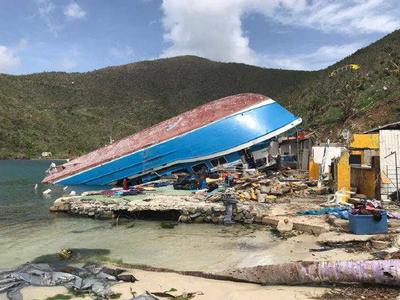 A ship lies upturned on the beach